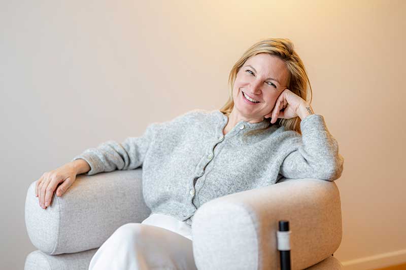 Bild von Katharina Bähner. Sie sitzt in einem gemütlichen Sessel in ihrer Praxis.